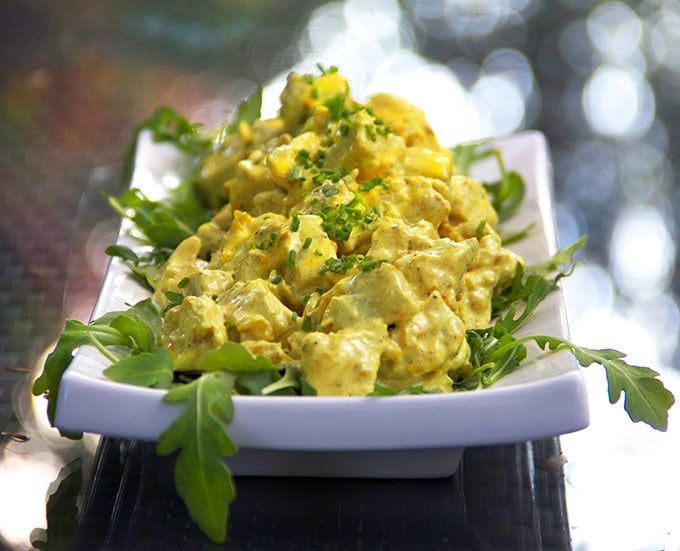 Creamy curried chicken salad on a bed of arugula