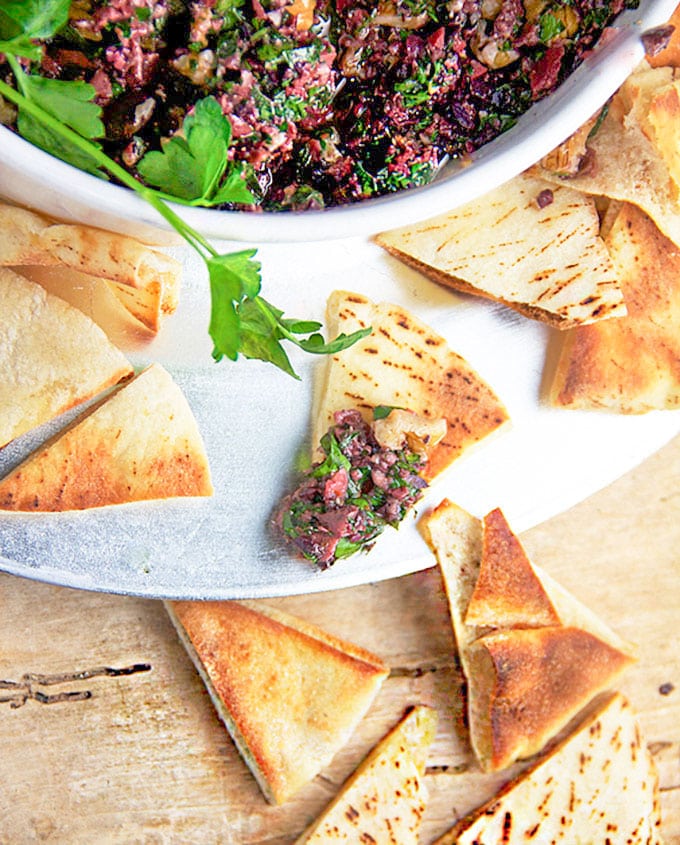 spicy turkish tapenade in a bowl surrounded by toasted pita triangles