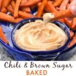 baked sweet potato fries in a blue serving bowl with a small bowl of chipotle aioli dip and one fry dipped into it.