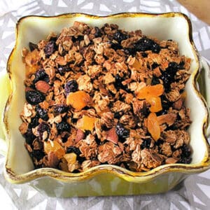 square yellow serving bowl filled with almond maple granola.