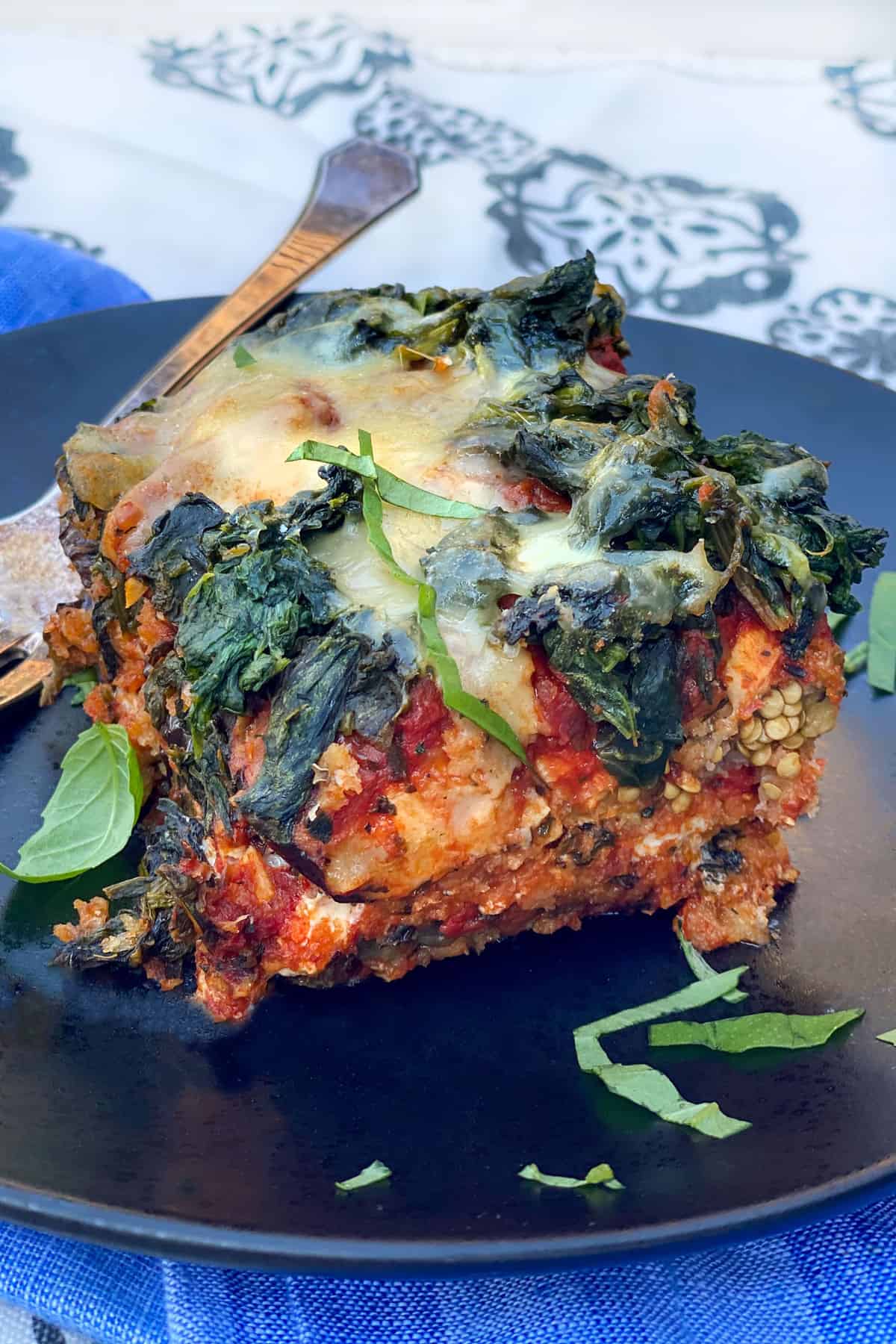 one slice of eggplant parmesan topped with spinach and cheese