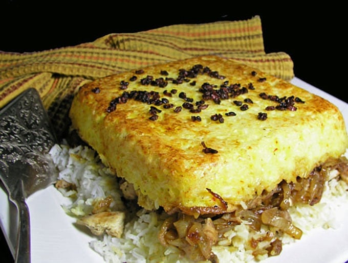 Persian Layered Chicken and Rice with Yogurt is a wonderful dish with layers of tender chicken, caramelized onions and saffron rice cooked in a casserole. The casserole is flipped over so the bottom layer, with its beautiful golden crust, becomes the top. It's served with garlicky yogurt sauce on the side.