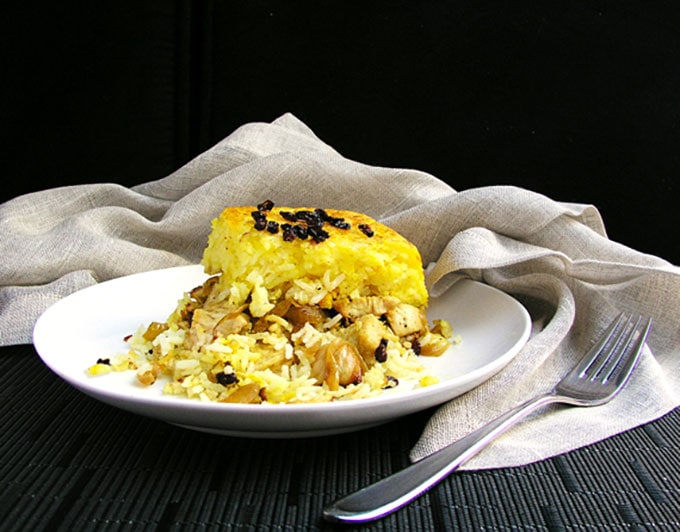 Persian Layered Chicken and Rice with Yogurt is a wonderful dish with layers of tender chicken, caramelized onions and saffron rice cooked in a casserole. The casserole is flipped over so the bottom layer, with its beautiful golden crust, becomes the top. It's served with garlicky yogurt sauce on the side.