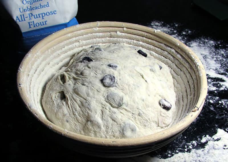 no-knead olive bread dough rising in a banneton