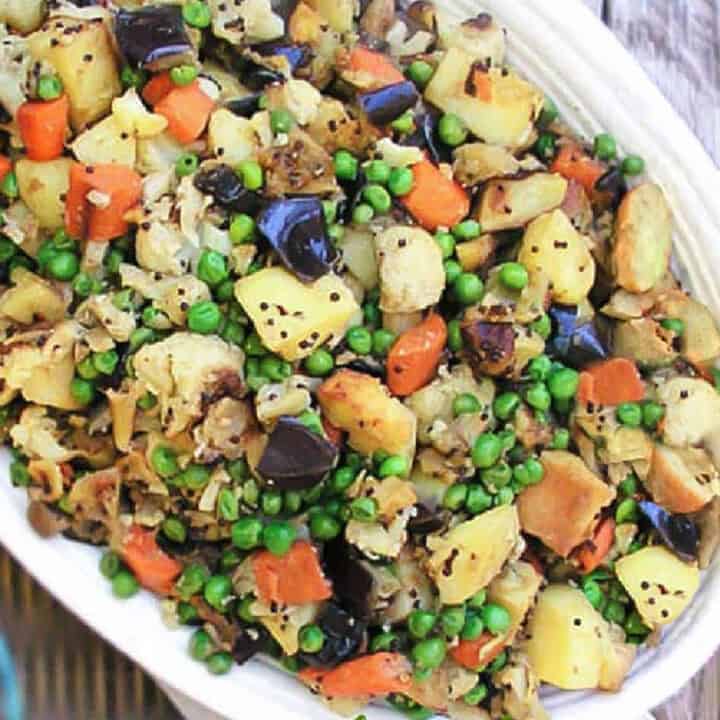 Mixed roasted vegetables on a white oval platter.