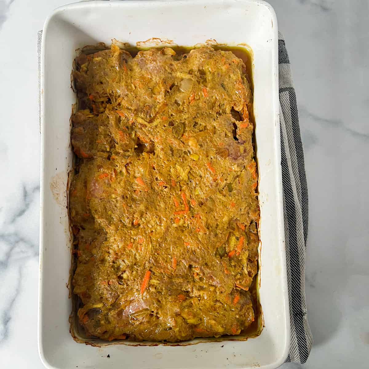 partially cooked meat mixture for bobotie, in a casserole.