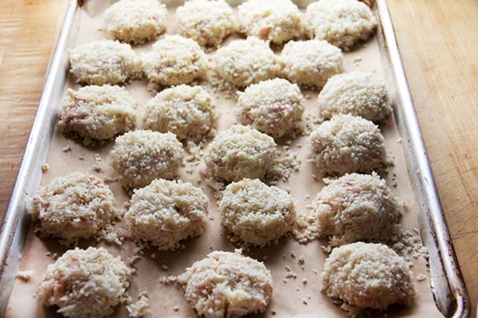 22 uncooked crab Cakes on a parchment lined baking tray