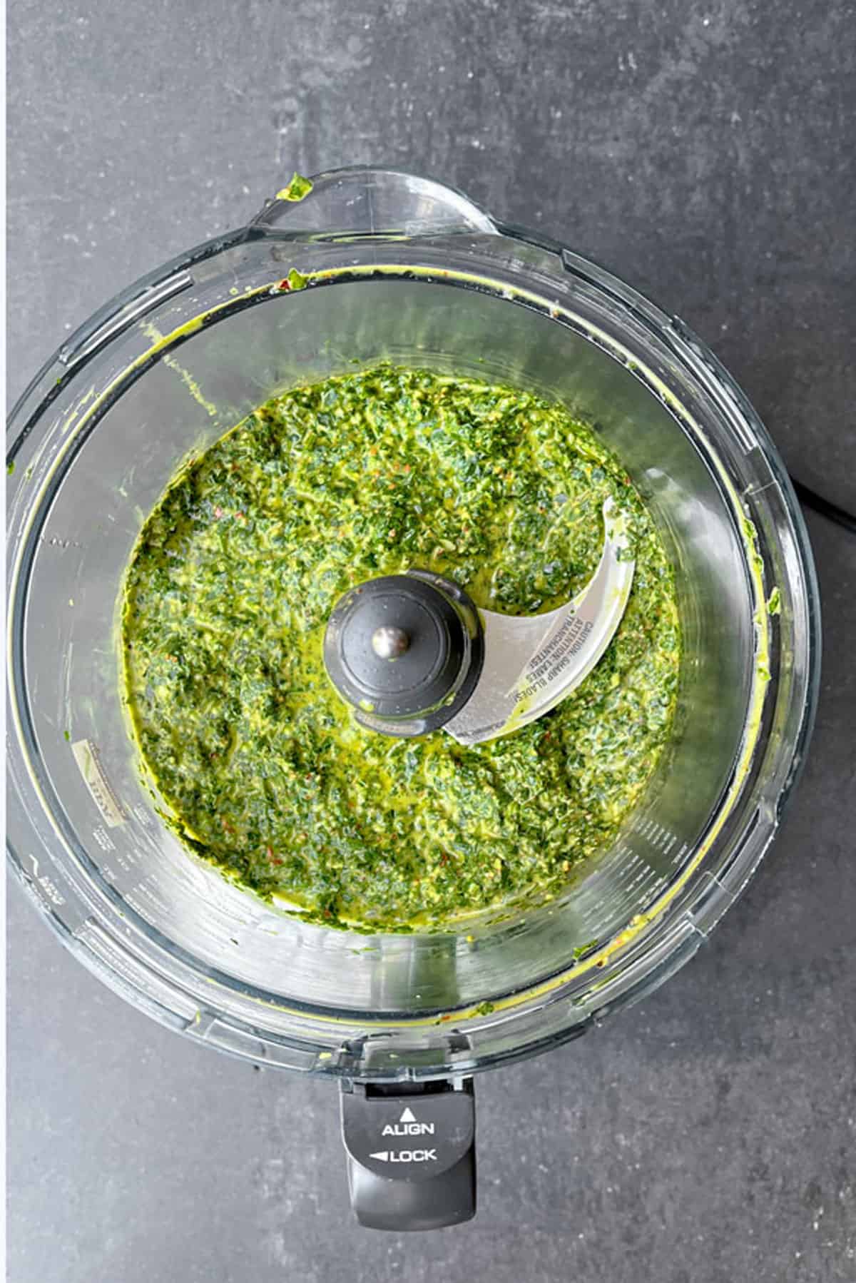 overhead shot of pureed green chimichurri sauce in a food processor