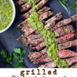Pinterest pin with an overhead shot of grilled skirt steak on a platter topped with a line of green chimichurri sauce down the miccle