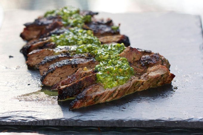 Grilled Skirt Steak with Chimichurri Sauce on a gray slate platter