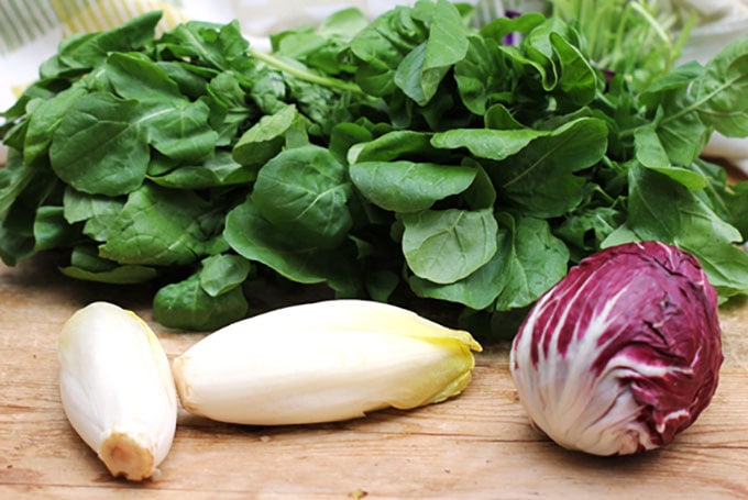Ingredients for Italian tricolore salad: a big bunch of arugula, two endives and one ball of radicchio