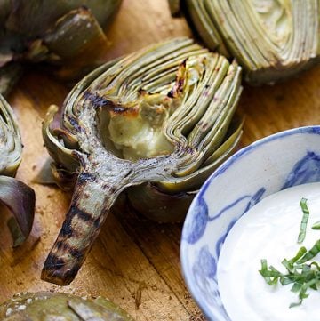 Grilled Artichokes are a fabulous appetizer for summer entertaining! You can do all the prep ahead of time. Just pop them on the grill right before serving. Grilling intensifies their wonderful flavor and the lemony aioli is the perfect companion.