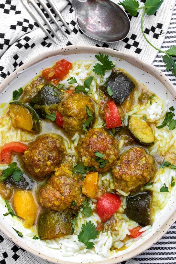 a bowl of Indian spiced lamb meatball stew with colorful ratatouille