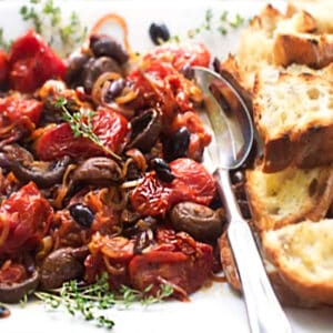 roasted tomatoes and mushrooms with grilled bread, on a platter.