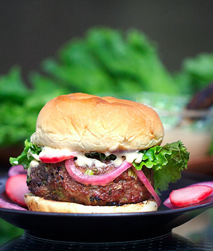 Grilled Korean burger on a bun with miso mayonnaise and pickled red onions and green leaf lettuce