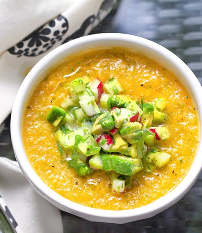 This Gazpacho can be made with yellow or red tomatoes. Serve it icy cold with the delicious topping of chopped cucumbers, radishes and avocados. The quintessential summer soup recipe l www.panningtheglobe.com 