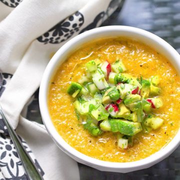 This Gazpacho can be made with yellow or red tomatoes. Serve it icy cold with the delicious topping of chopped cucumbers, radishes and avocados. The quintessential summer soup recipe l www.panningtheglobe.com