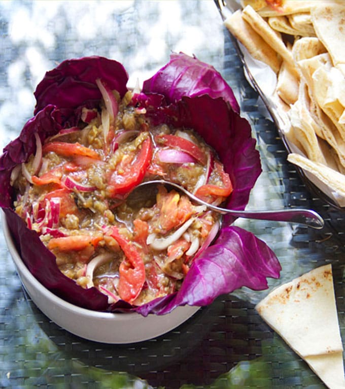 This roasted eggplant dip recipe is one of my favorite summer appetizers, and it’s so simple to make. Just bake the eggplant, chop it up, and mix it with sliced tomato and red onion plus some oil, vinegar, garlic, salt and pepper. Serve it with toasted pita points, tortilla chips or crackers. 