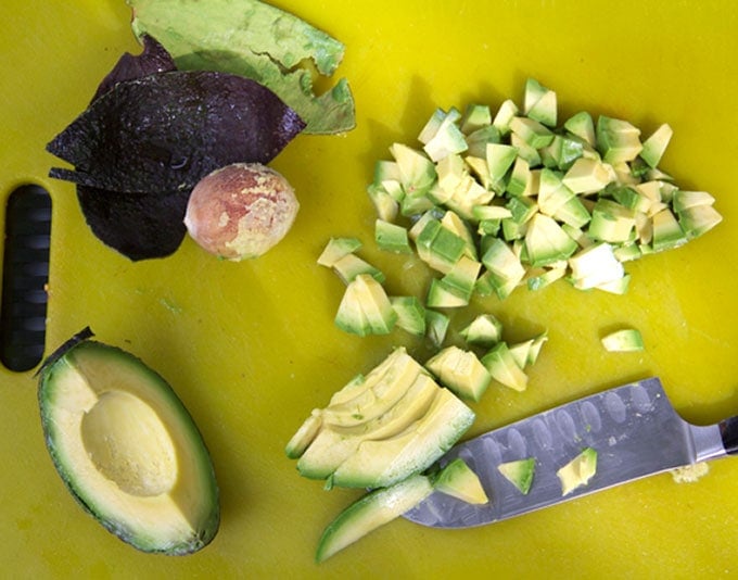 This Gazpacho can be made with yellow or red tomatoes. Serve it icy cold with the delicious topping of chopped cucumbers, radishes and avocados. The quintessential summer soup recipe l www.panningtheglobe.com 