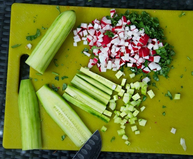 This Gazpacho can be made with yellow or red tomatoes. Serve it icy cold with the delicious topping of chopped cucumbers, radishes and avocados. The quintessential summer soup recipe l www.panningtheglobe.com 