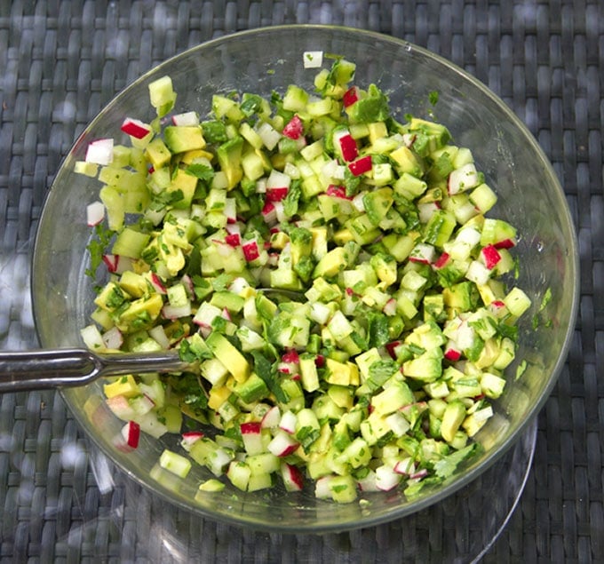 This Gazpacho can be made with yellow or red tomatoes. Serve it icy cold with the delicious topping of chopped cucumbers, radishes and avocados. The quintessential summer soup recipe l www.panningtheglobe.com 