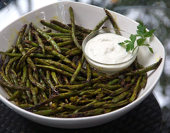 Indonesian Grilled Green Beans in a large serving bowl with a small glass bowl filled with aioli dipping sauce