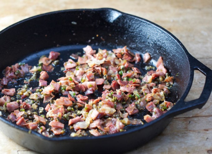 Cast iron skillet with sautéed prosciutto capers and garlic