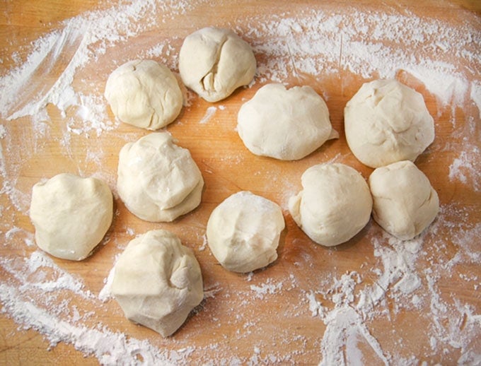 10 balls of dough on a floured surface