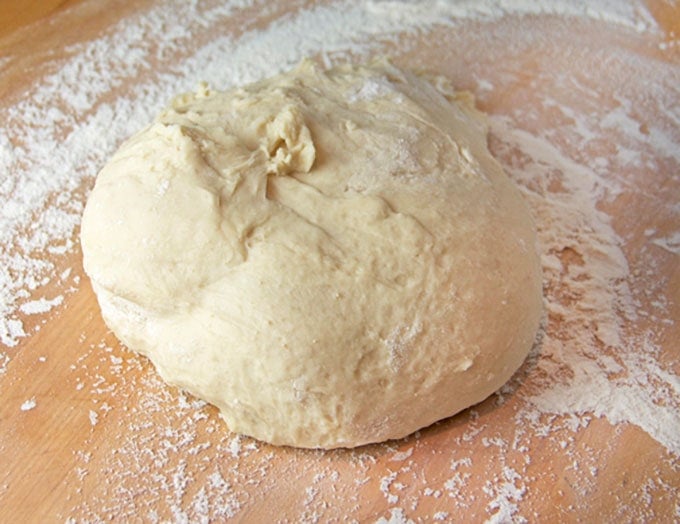 A large ball of dough on a floured surface.