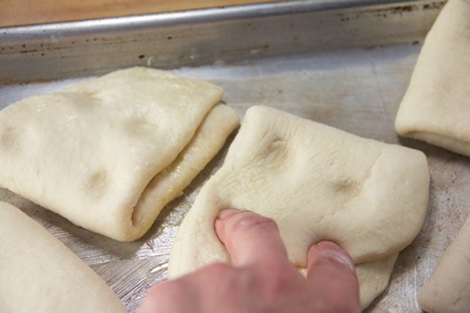 two fingers pressing into a piece of dough.