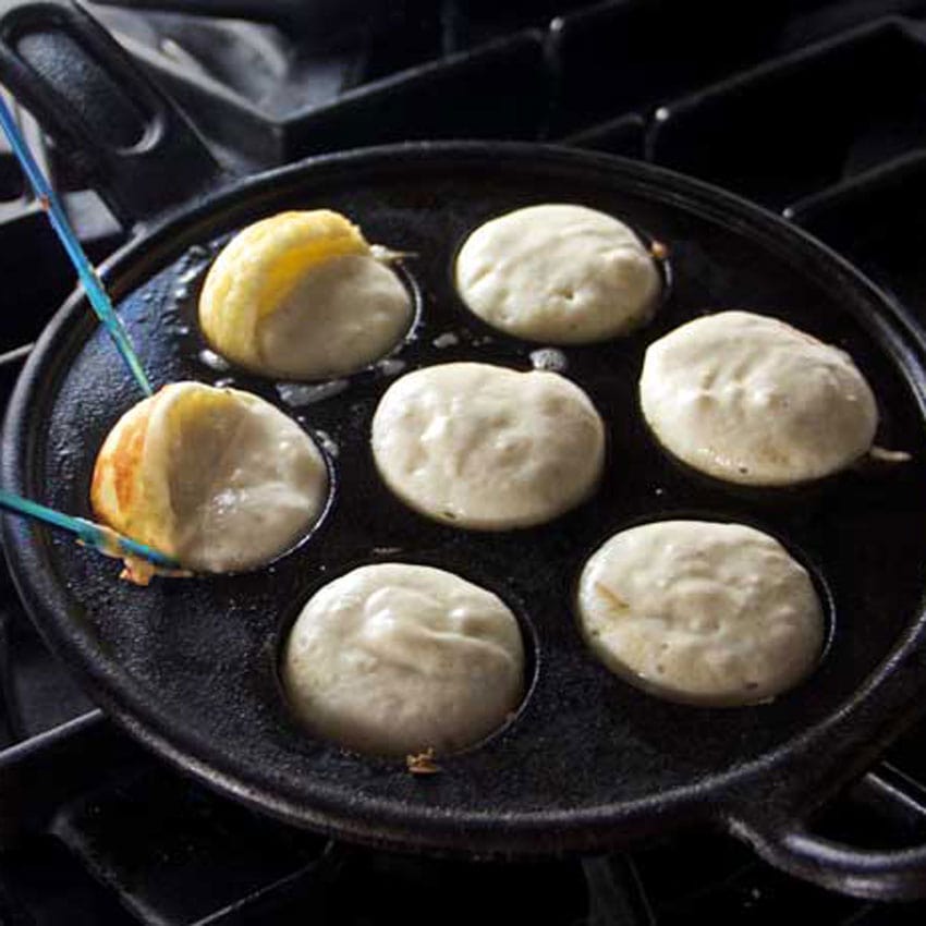 Showing how to form aebleskiver using two pointy knitting needles to turn the batter in the pan to form spheres.