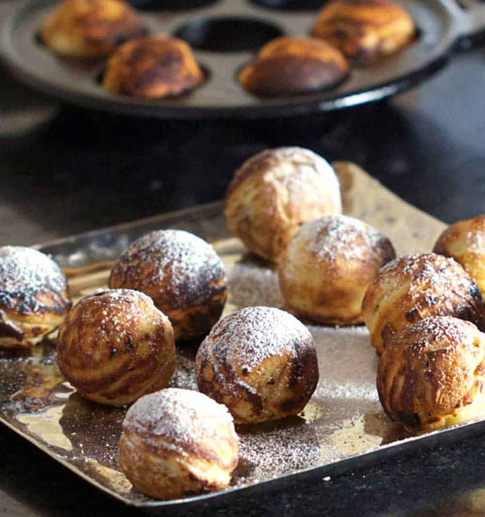 platter of Danish aebleskiver pancake balls sprinkled with powdered sugar