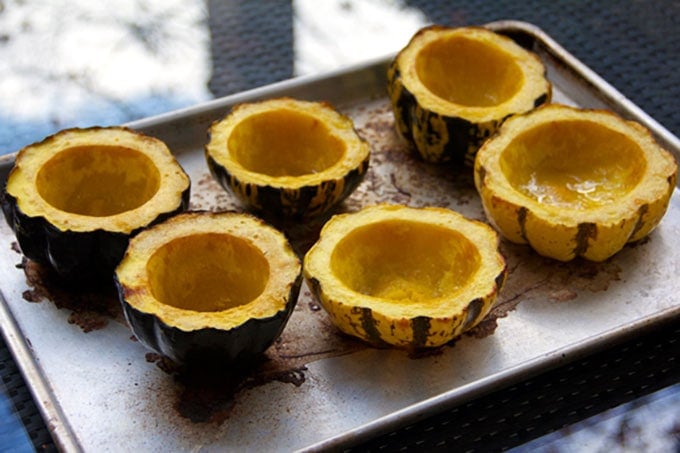 6 roasted acorn squash halves on a rimmed baking sheet