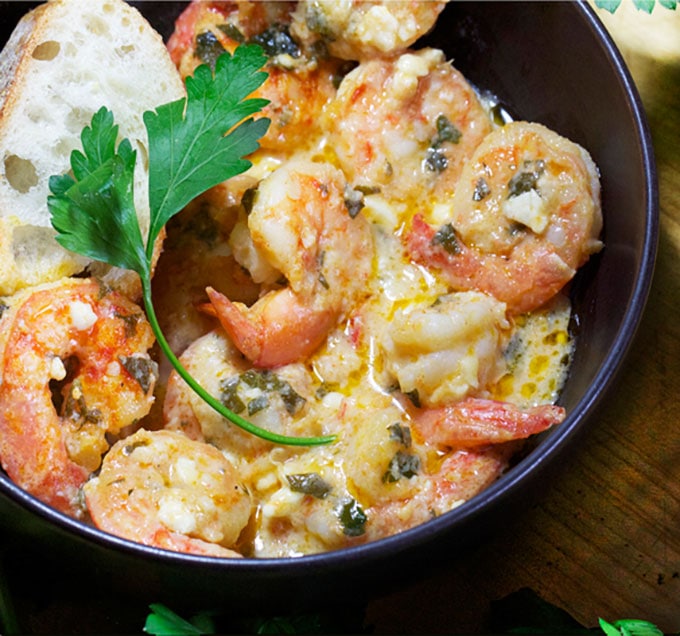 A bowl with greek style garlicky shrimp and feta and bread