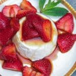vanilla panna cotta surrounded by and topped with balsamic marinated strawberries
