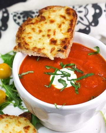 Grilled cheese and tomato soup is the ultimate comfort food pairing and the perfect lunch combo. Here's a special recipe for delicious spiced-up tomato soup and open-face oven grilled cheese with some secret ingredients that make it extra tasty.