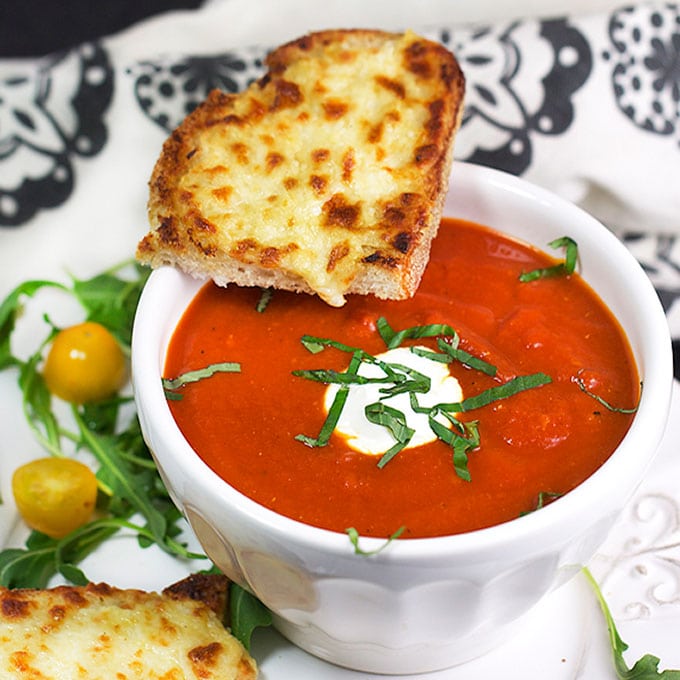 Grilled cheese and tomato soup is the ultimate comfort food pairing and the perfect lunch combo. Here's a special recipe for delicious spiced-up tomato soup and open-face oven grilled cheese with some secret ingredients that make it extra tasty.