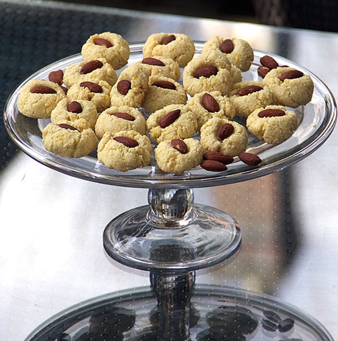 raised glass cake plate topped with lots of flourless Spanish almond cookies