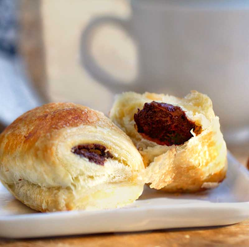 two homemade Pain Au Chocolate on a white square plate