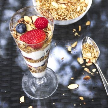 In this yogurt parfait recipe, toasted quinoa with coconut & almonds is a high protein, gluten-free alternative to granola. It's crunchy and nutty and the best thing ever to layer with creamy yogurt and fresh berries l www.panningtheglobe.com