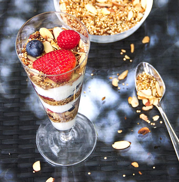 In this yogurt parfait recipe, toasted quinoa with coconut & almonds is a high protein, gluten-free alternative to granola. It's crunchy and nutty and the best thing ever to layer with creamy yogurt and fresh berries l www.panningtheglobe.com