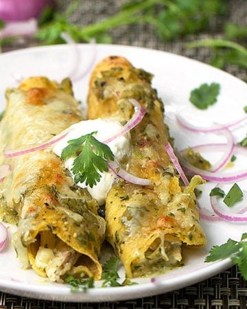 Chicken Enchiladas Verdes is a beloved Mexican recipe but it's the roasted tomatillo salsa that takes it over the top! Chicken, cheese, corn tortillas + roasted tomatillo sauce = super delicious! | panningtheglobe.com