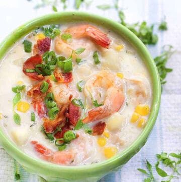 bowl of shrimp and corn chowder topped with crumbled bacon and chopped scallions