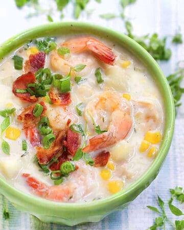 bowl of shrimp and corn chowder topped with crumbled bacon and chopped scallions