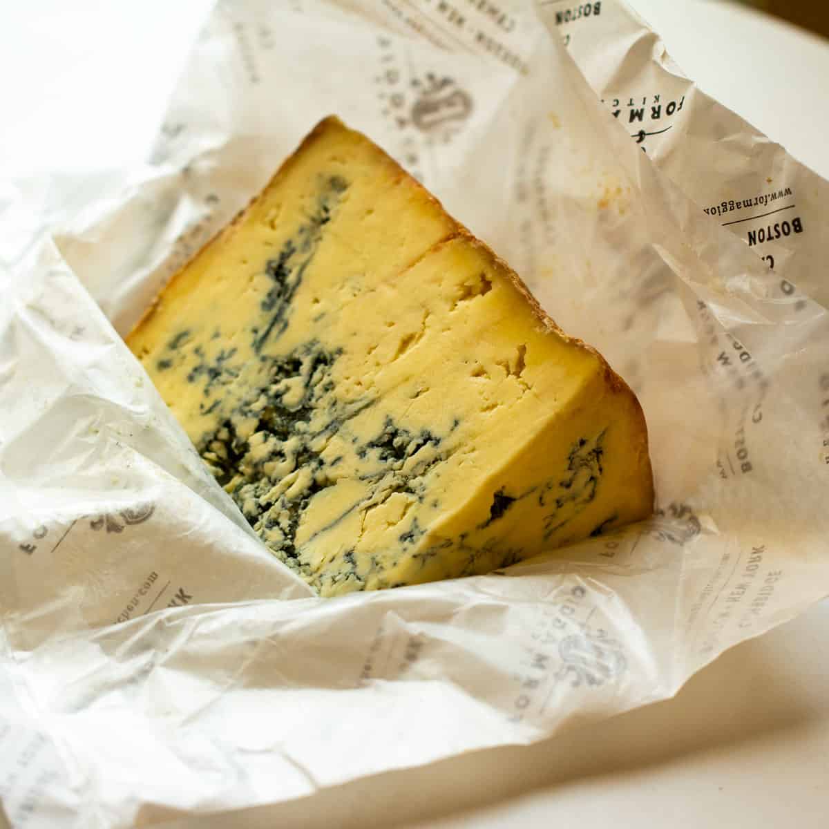 A hunk of Colston Basset Stilton cheese on a white wrapper