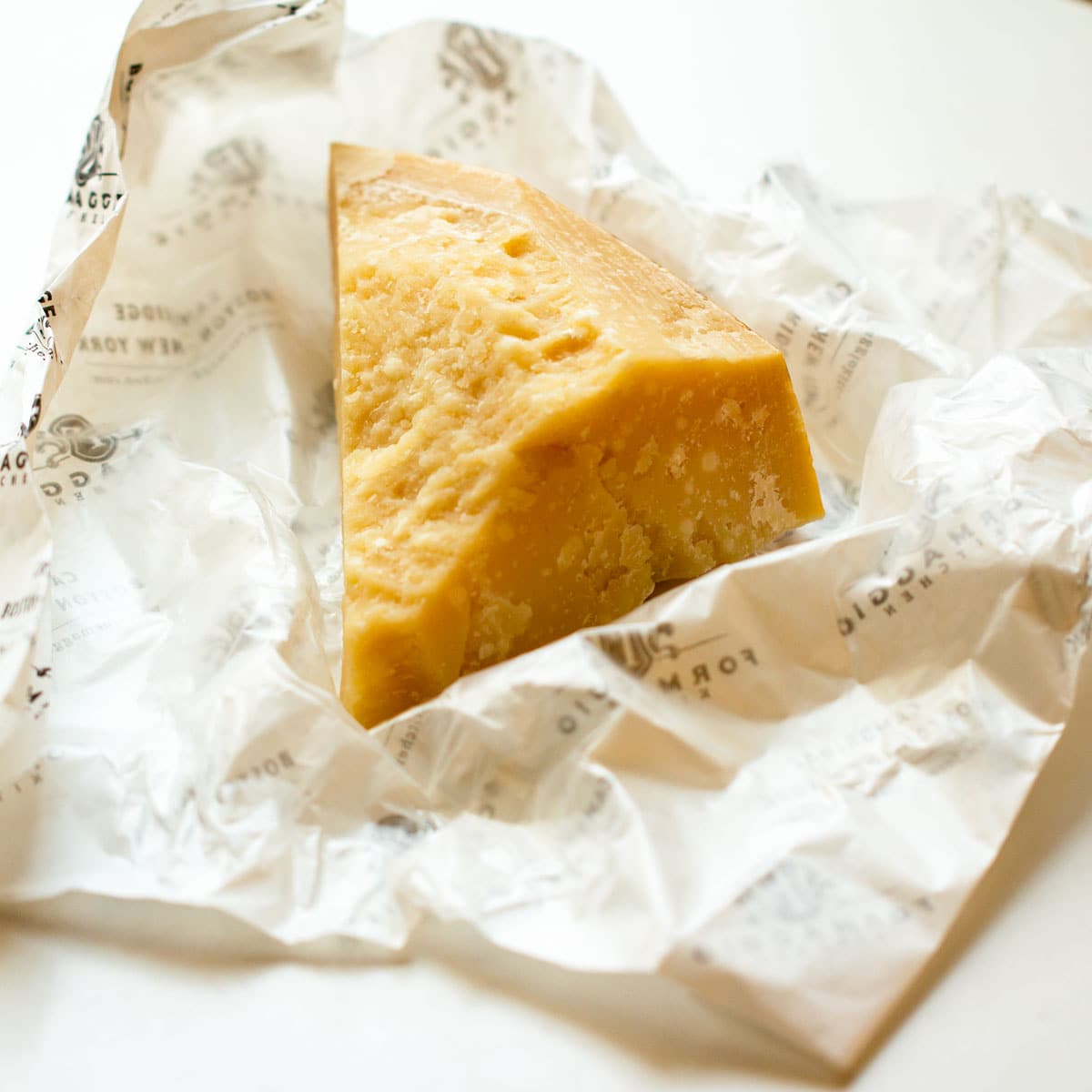A hunk of Parmigiano Reggiano on a white wrapper