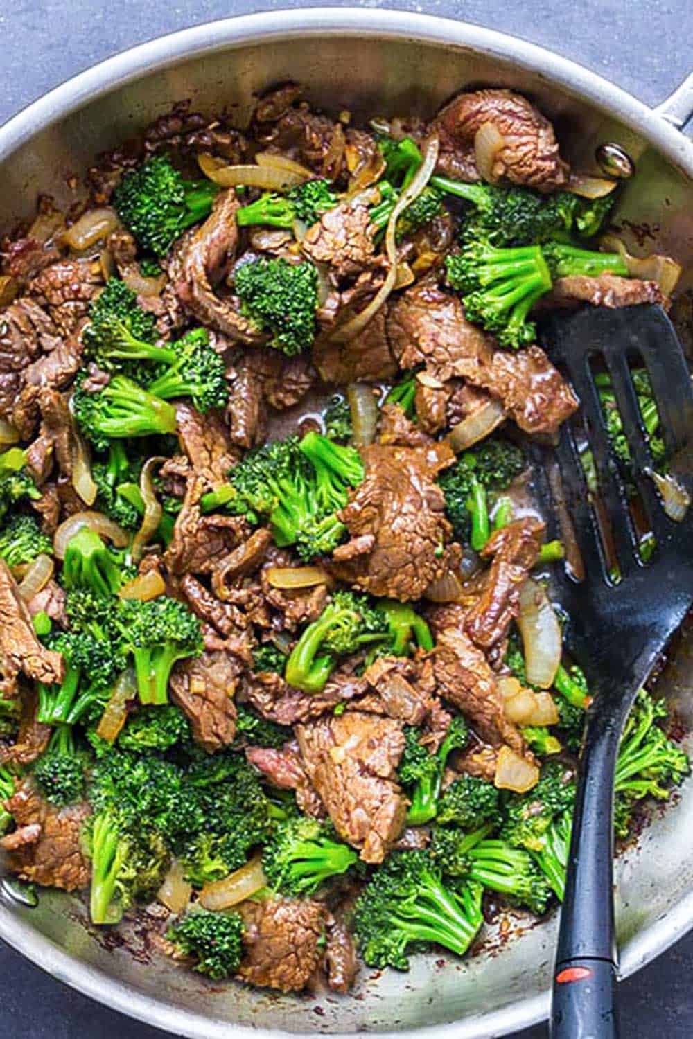 overhead shot of Chinese Beef and Broccoli in a wok with a black spatula