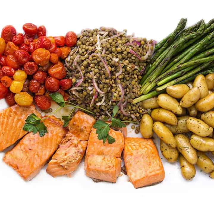 salmon nicoise on a platter: broiled salmon, fingerling potatoes, roasted tomatoes, asparagus and lentil salad.