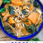 blue bowl filled with colorful Moroccan chicken stew with sweet potatoes and kale