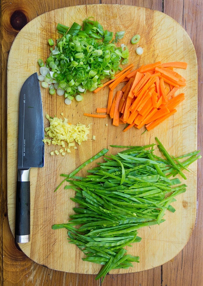 Sliced and chopped carrots, snow peas, scallions and ginger, for 7 Flavor Precious Chicken